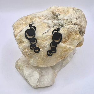 Open image in slideshow, These abstract moons are just the thing to make a statement with either jeans or a little black dress or anything in between. Lightweight and waterproof these earrings go with the tides. Earring is laser cut from up-cycled bicycle inner tubes, made to order in the USA with stainless steel findings. Wear the rubber nut backs because these little earrings will fly away!
