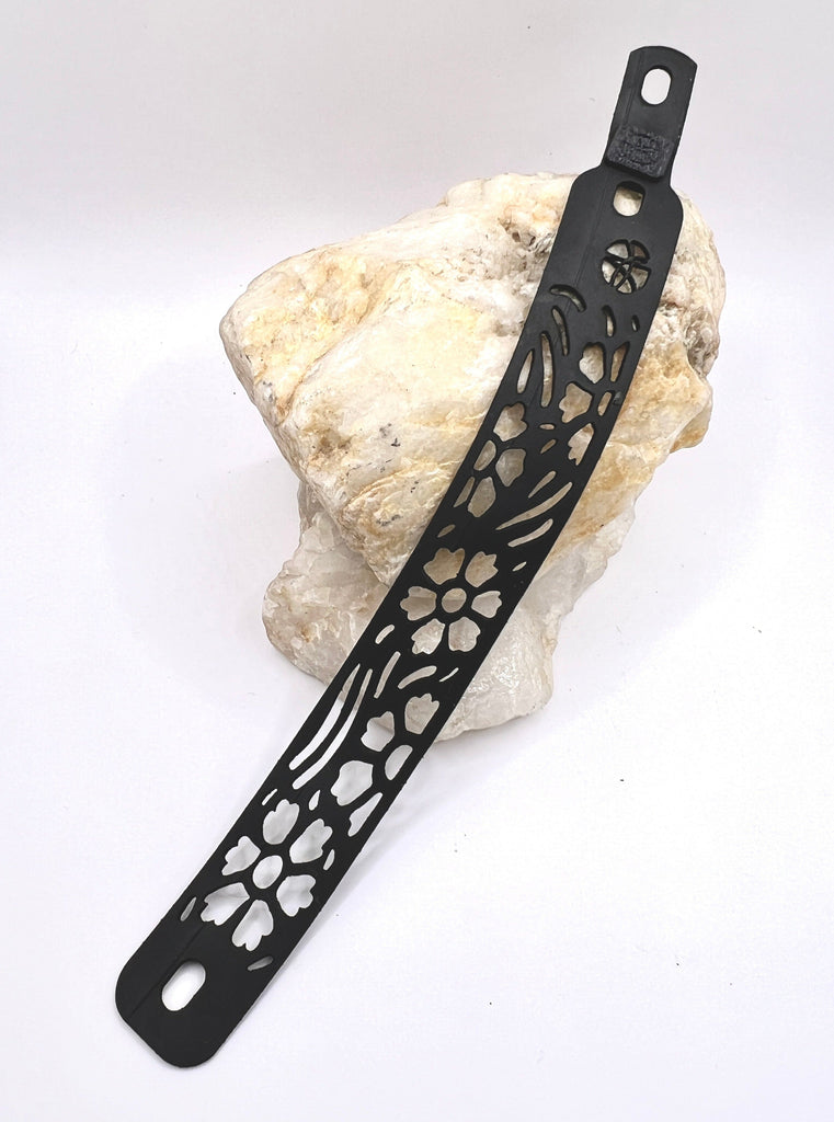 A simple floral pattern is representative of the flowers found on the prairie. Wide open fields dotted with flowers and a soft breeze with not a care in the world, is how this bracelet wants you to feel! The bracelet is edgy and looks like a tattoo from afar. It is made from up-cycled bicycle inner tubes, made to order in the USA with a recycled 3-d filament printed link.  2 sizes, 3 options within each.